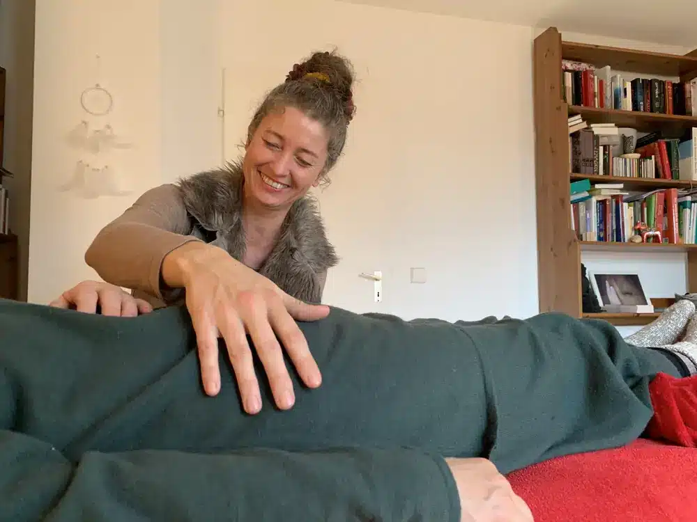 Alma lacht und legt einer Patientin die Hand auf den Bauch.